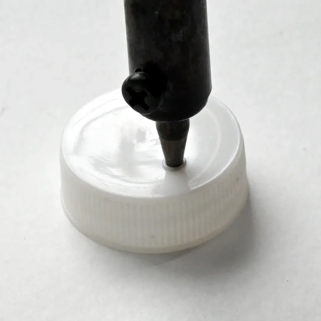 Making dispense hole in the medicine bottle lid for resistor dispenser and storage solution